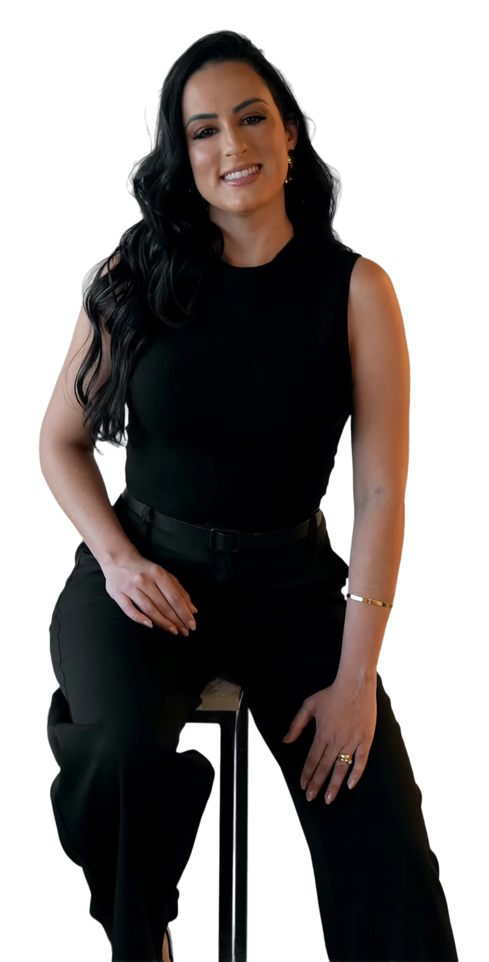 Dra. Mallu Cerutti sorrindo, de blusa preta, sentada numa banqueta